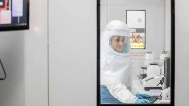 dpatop - 28 May 2021, South Africa, Johannesburg: A woman in a protective suit works in a high-security laboratory of the National Institute for Communicable Diseases (NICD) during a visit by Federal Health Minister Spahn. At the request of Chancellor Merkel, Spahn is travelling to South Africa at the same time as the state visit of French President Macron in order to support the establishment of a vaccine production facility in Africa together with France. (to dpa: Germany gives South Africa financial aid for vaccine production) Photo: Christoph Soeder/dpa (Photo by Christoph Soeder / DPA / dpa Picture-Alliance via AFP)