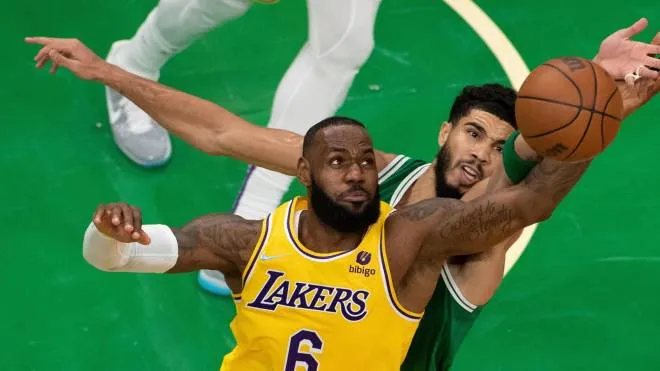epa09592879 Boston Celtics forward Jayson Tatum (R) and Los Angeles Lakers forward LeBron James (L) reach for the loose ball during the second quarter at the TD Garden in Boston, Massachusetts, USA, 19 November 2021.  EPA/CJ GUNTHER SHUTTERSTOCK OUT