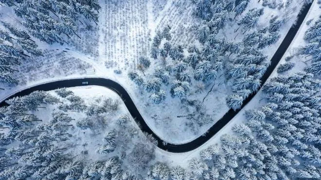 An aerial view shows a snow covered landscape on a sunny winter day of January 6, 2022, near Winterberg, western Germany. (Photo by Ina FASSBENDER / AFP)