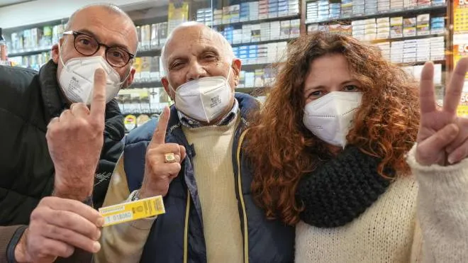 I proprietari della tabaccheria di viale Mazzini a Roma mostrano la matrice del biglietto vincente da 5 milioni di euro