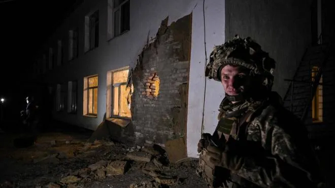 An Ukrainian soldier stands guard near debris after the reported shelling of a kindergarten in the settlement of Stanytsia Luhanska, Ukraine, on February 17, 2022. - U.S. Defence Secretary Lloyd Austin warned on February 17, 2022, of a provocation by Moscow to justify military intervention in Ukraine after "disturbing" reports of mutual accusations of bombing between the Ukrainian military and pro-Russian separatists. (Photo by Aris Messinis / AFP)