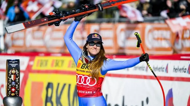 epa09788664 Third placed Sofia Goggia of Italy celebrates on the podium for the Women's Downhill race at the FIS Alpine Skiing World Cup in Crans-Montana, Switzerland, 27 February 2022.  EPA/JEAN-CHRISTOPHE BOTT