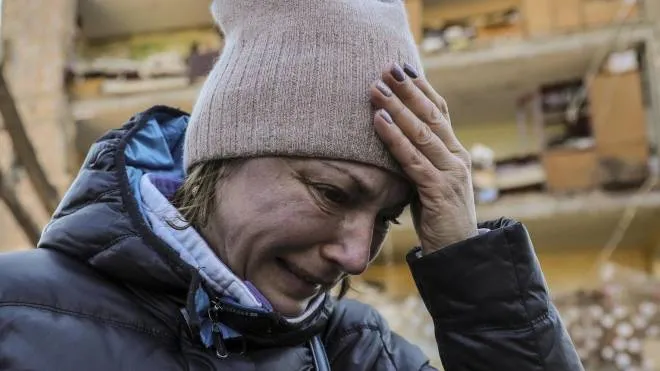 Una donna piange davanti a un palazzo di Kiev centrato dai missili delle forze armate del Cremlino