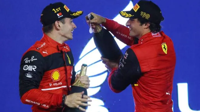 Winner Ferrari's Monegasque driver Charles Leclerc (L) and second place Ferrari's Spanish driver Carlos Sainz Jr celebrate on the podium winning the Bahrain Formula One Grand Prix at the Bahrain International Circuit in the city of Sakhir on March 20, 2022. (Photo by Giuseppe CACACE / AFP)