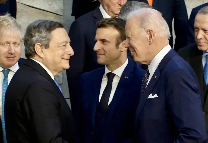 Il saluto tra Mario Draghi (74 anni) e Joe Biden (79) al vertice straordinario della Nato. Sullo sfondo Boris Johnson (57), Emmanuel Macron (44) e Tayyip Erdogan (68)