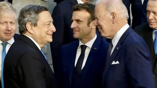Il saluto tra Mario Draghi (74 anni) e Joe Biden (79) al vertice straordinario della Nato. Sullo sfondo Boris Johnson (57), Emmanuel Macron (44) e Tayyip Erdogan (68)