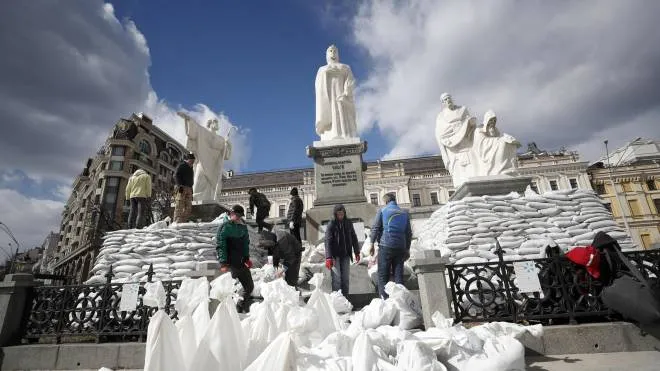Volontari cercano di proteggere con sacchi di sabbia il monumento dedicato alla principessa Olga a Kiev