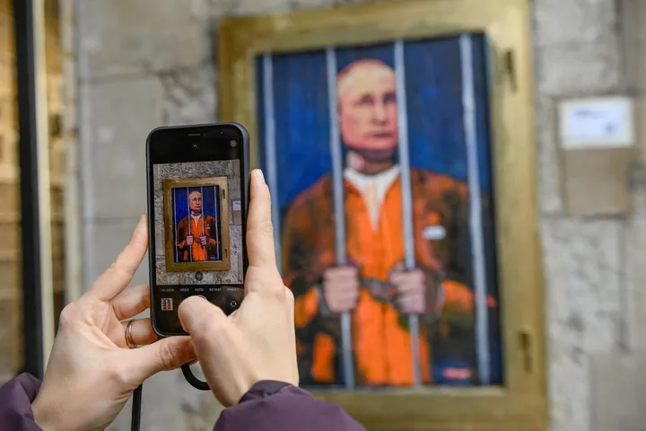 Barcellona: uno smartphone per scattare le immagini di una nuova opera dello street artist italiano TvBoy che ritrae il presidente russo Putin in prigione