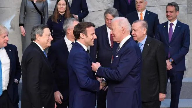 US President Joe Biden shakes hands with France's President Emmanuel Macron (C,L) next to Britain's Prime Minister Boris Johnson (L) and Italy's Prime Minister Mario Draghi (2L) at NATO Headquarters in Brussels on March 24, 2022. (Photo by JOHN THYS / AFP)