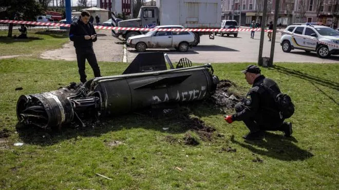 Ukrainian police inspect the remains of a large rocket with the words "for our children" in Russian next to the main building of a train station in Kramatorsk, eastern Ukraine, that was being used for civilian evacuations, that was hit by a rocket attack killing at least 35 people, on April 8, 2022. (Photo by FADEL SENNA / AFP)