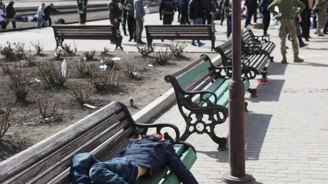Il cadavere di una giovane vittima dell’attentato alla stazione di Kramatorsk appoggiato su una panchina nei pressi della stazione presa di mira dalla Russia