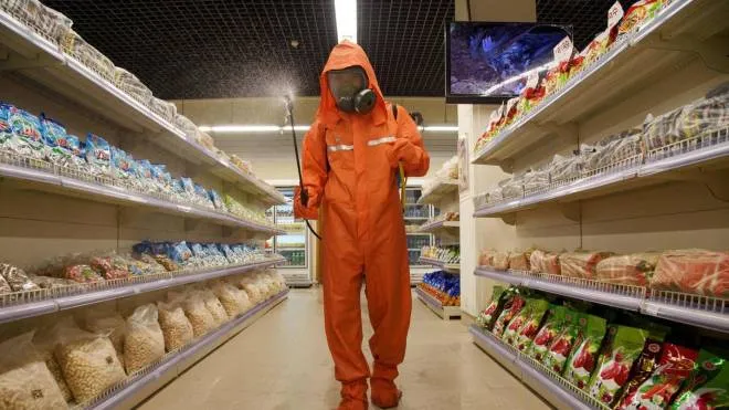 (FILES) In this file picture taken on September 27, 2021, a health official sprays disinfectant as part of preventative measures against Covid-19, in the Daesong Department Store in Pyongyang. - North Korea on May 12, 2022 confirmed its first-ever case of Covid-19, with state media declaring it a "severe national emergency incident" after more than two years of purportedly keeping the pandemic at bay. (Photo by KIM Won Jin / AFP)