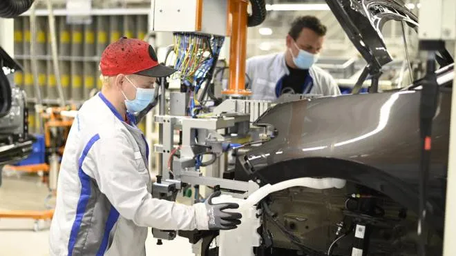 epa08379554 A handout photo made available by Volkswagen shows to workers wearing face masks in the ID.3 electric car production line at the Volkswagen (VW) factory in Zwickau, Germany, 23 April 2020. According to reports, Volkswagen resumed production in Zwickau on 23 April after suspending it due to the fall in demand for vehicles over the SARS-CoV-2 coronavirus pandemic which causes the Covid-19 disease.  EPA/VOLKSWAGEN / HANDOUT  HANDOUT EDITORIAL USE ONLY/NO SALES