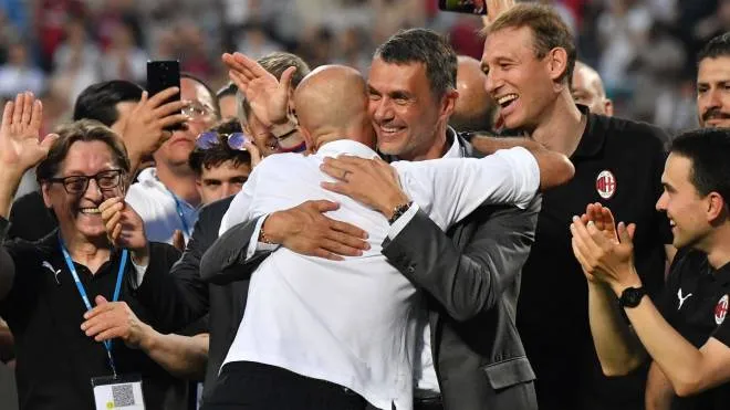 AC Milan's Italian head coach Stefano Pioli (L) embraces AC Milan's former player turned technical director, Paolo Maldini during the winner's trophy ceremony after AC Milan won the Italian Serie A football match between Sassuolo and AC Milan, securing the "Scudetto" championship on May 22, 2022 at the Mapei - Citta del Tricolore stadium in Sassuolo. (Photo by Tiziana FABI / AFP)