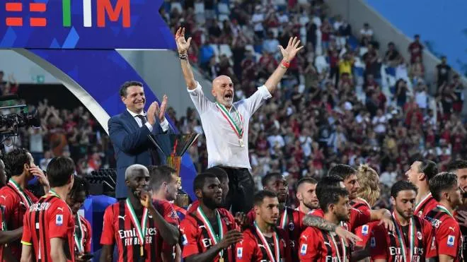 AC Milan's Italian head coach Stefano Pioli (Top C) and AC Milan's players celebrate during the winner's trophy ceremony after AC Milan won the Italian Serie A football match between Sassuolo and AC Milan, securing the "Scudetto" championship on May 22, 2022 at the Mapei - Citta del Tricolore stadium in Sassuolo. (Photo by Tiziana FABI / AFP)