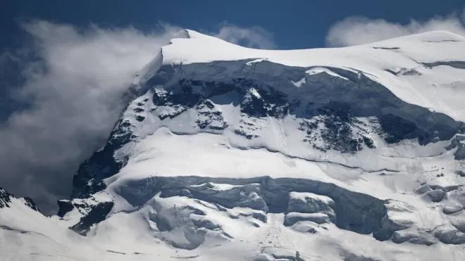 This photograph taken on May 27, 2022, shows a partial view of the Grand Combin massif mountain near Verbier, where several mountaineers had been caught up in falling seracs -- columns of glacial ice formed by crevasses near the Italian border in the Wallis region. - "Around 15 mountaineers were there," the Wallis police said in a statement. "Several climbers were impacted. Regrettably, there are victims. Other mountaineers on the spot were evacuated," the statement said, adding that further details would be given in due course. (Photo by Fabrice COFFRINI / AFP)