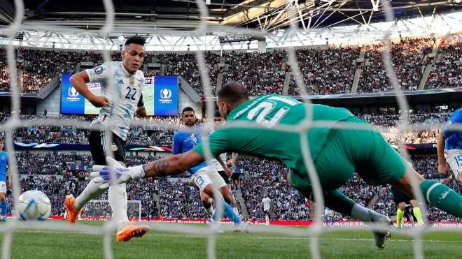 Argentina's striker Lautaro Martinez (L) shoots to score the opening goal of the 'Finalissima' International friendly football match between Italy and Argentina at Wembley Stadium in London on June 1, 2022. - The Azzurri face the South American continental champions in the inaugural Finalissima at Wembley. (Photo by Adrian DENNIS / AFP)