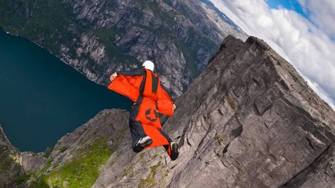 sabattini - "Kjerag, Norway - August 21, 2010: a BASE jumper in wingsuit  jumps off a cliff at Kjerag plateau, Norway. Wingsuit cliff jumping and terrain flying are advanced BASE jumping disciplines that make human flight possible."