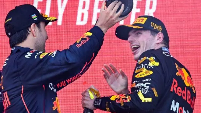 Winner Red Bull's Dutch driver Max Verstappen (R) and second placed Red Bull's Mexican driver Sergio Perez celebrate on the podium after the Formula One Azerbaijan Grand Prix at the Baku City Circuit in Baku on June 12, 2022. (Photo by NATALIA KOLESNIKOVA / AFP)
