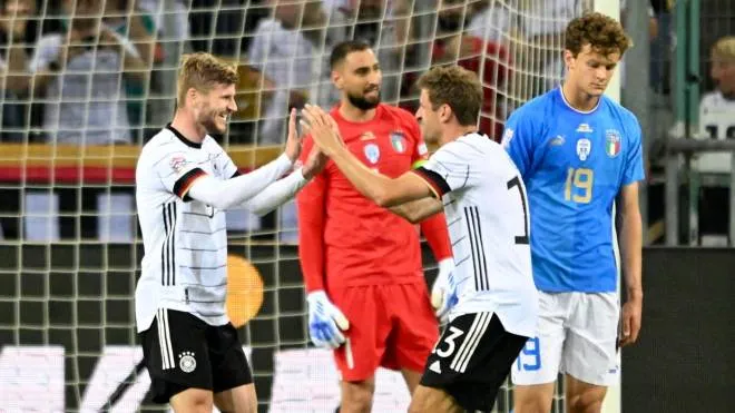 epa10013386 Timo Werner (L) of Germany celebrates with teammate Thomas Mueller (2-R) after scoring the 5-0 lead against Italy's goalkeeper Gianluigi Donnarumma (back) during the UEFA Nations League soccer match between Germany and Italy in Moenchengladbach, Germany, 14 June 2022.  EPA/SASCHA STEINBACH