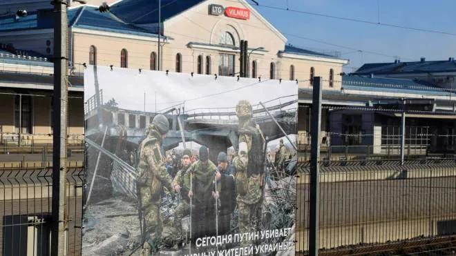 (FILES) In this file photo taken on March 25, 2022 a photo taken by Ukrainian photographer Maxim Dondiuk is seen next to other photographs of Russia's war in Ukraine as part of an exhibition at the railway station in Vilnius, Lithuania, where transit trains from Moscow to Kaliningrad make a stop over. - Lithuania said on June 20, 2022 its ban on rail transit for EU-sanctioned goods through Russia's exclave of Kaliningrad is in line with European sanctions, after Moscow slammed the move and vowed a response. (Photo by PETRAS MALUKAS / AFP) / RESTRICTED TO EDITORIAL USE - MANDATORY MENTION OF THE ARTIST UPON PUBLICATION - TO ILLUSTRATE THE EVENT AS SPECIFIED IN THE CAPTION