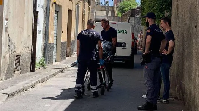 Il cadavere della 50enne viene portato via dall’abitazione di Sampierdarena