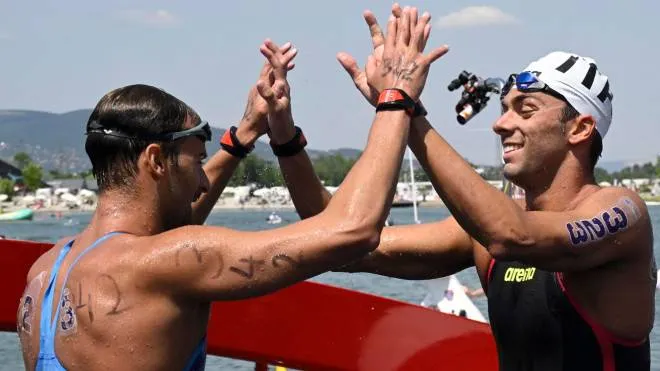 epa10041033 Winner Gregorio Paltrinieri of Italy (R) and his second-placed compatriot Domenico Acerenza (R) celebrate after the men's open water 10km swimming race of 19th FINA World Championships in Lake Lupa in Budakalasz, Hungary, 29 June 2022.  EPA/Zsolt Szigetvary HUNGARY OUT
