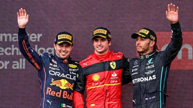 epa10050037 Second placed Mexican Formula One driver Sergio Perez of Red Bull Racing (L), first placed Spanish Formula One driver Carlos Sainz of Scuderia Ferrari (C) and third placed British Formula One driver Lewis Hamilton of Mercedes-AMG Petronas (R) celebrate on the podium after the Formula One Grand Prix of Britain at the Silverstone Circuit, Silverstone, Britain, 03 July 2022.  EPA/CHRISTIAN BRUNA