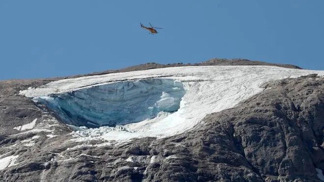 A helicopter flies over the avalanche area to search for people still missing on the Marmolada glacier in Canazei, Italy, 04 July 2022. Rescuers resumed the search for survivors today after the avalanche set off by the collapse of the glacier, the largest in the Italian Alps, killed at least six people and injured eight others.  ANSA/ANDREA SOLERO