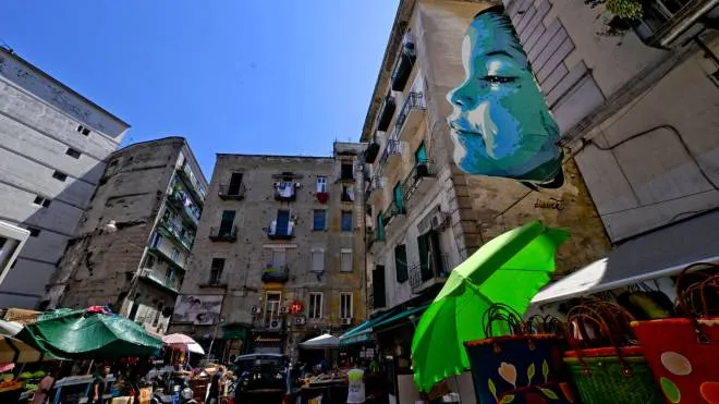 Un grande murales con il volto di una bambina nel  quariere Montesanto a Napoli dove e' stata sfregiata con un coltello una ragazza di 12 anni, 12 luglio 2022. ANSA / CIRO FUSCO