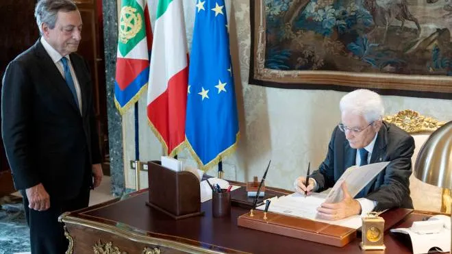 epa10084606 A handout picture made available by the Quirinal Presidential Palace (Palazzo del Quirinale) Press Office shows Italian President Sergio Mattarella signing a document as he meets with Prime Minister Mario Draghi (L) at the Quirinal Palace in Rome, Italy, 21 July 2022. Mattarella announced on the day that he signed a decree to dissolve parliament for a general election to be held within 70 days after Prime Minister Draghi resigned following the collapse of his ruling coalition.  EPA/PAOLO GIANDOTTI/QUIRINAL PALACE PRESS OFFICE HANDOUT  HANDOUT EDITORIAL USE ONLY/NO SALES