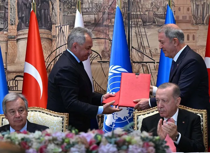Il ministro russo Sergei Shoigu e il turco Hulusi Akar suggellano l’accordo, mentre il presidente Erdogan applaude