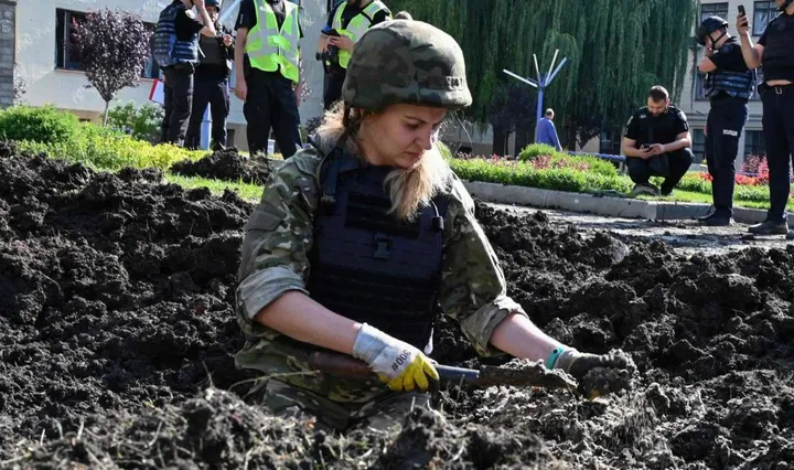 Esperti della polizia ucraina al lavoro in un cratere causato dagli ultimi bombardamenti dei russi sulla città di Kharkiv