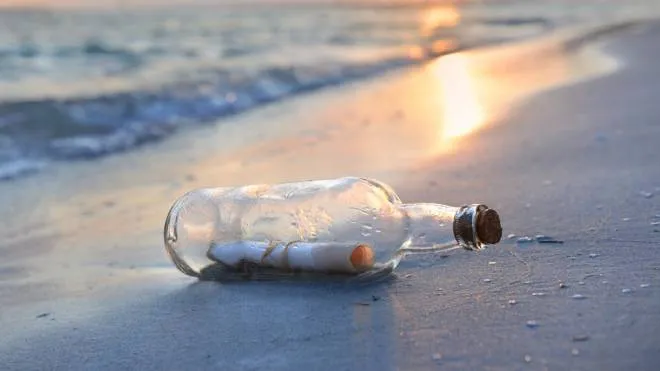 Messaggio in bottiglia sulla riva del mare
