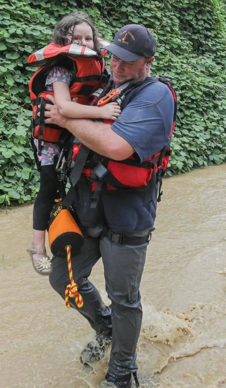 Un soccorritore porta in salvo una bambina appena soccorsa
