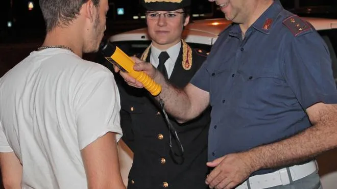 Un carabiniere esegue un controllo all’uscita di un locale del tasso alcolemico