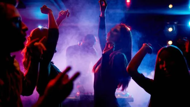 Group of dancing young people enjoying night in club