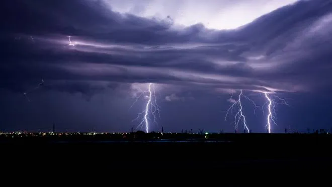 Lightning storm with several bolts striking over a city in Texas.