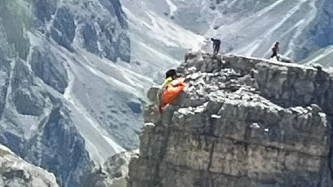 Salvataggio a 2.700 metri di altitudine oggi sulle Tre Cime di Lavaredo per il pilota di un parapendio che, avvicinatosi troppo alla roccia, ha perso il controllo della vela, sbattendo contro la parete, pochi metri sotto la cima della 'Piccolissima'', 14 agosto 2022. Due alpinisti che si trovavano in vetta hanno subito lanciato la loro corda al pilota perch� si assicurare e hanno atteso l'arrivo dei soccorsi. L'uomo, un 40enne di Dobbiaco (Bolzano), � stato raggiunto dall'elicottero di Dolomiti Emergency, con una squadra del Soccorso alpino della Guardia. Il tecnico di elisoccorso si � calato con il verricello in hovering sulla vetta, ed ha aiutato l'uomo ad assicurarsi a sua volta al verricello che l'ha portato a bordo. Infine il 40enne, con probabili contusioni allo sterno e all'anca, � stato trasportato all'ospedale di Cortina. (NPK)
ANSA/ US/ SOCCORSO ALPINO
+++ ANSA PROVIDES ACCESS TO THIS HANDOUT PHOTO TO BE USED SOLELY TO ILLUSTRATE NEWS REPORTING OR COMMENTARY ON THE FACTS OR EVENTS DEPICTED IN THIS IMAGE; NO ARCHIVING; NO LICENSING +++