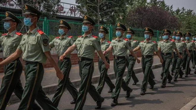 epa08482074 Chinese soldiers wearing face masks march next to the closed Xinfadi market building in Fengtai district, Beijing, China, 13 June 2020. One of Beijing's largest markets, Xinfadi in Fengtai district, was shut down on 13 June, and the district placed under lockdown following the confirmation of new domestic coronavirus cases.  EPA/ROMAN PILIPEY  EPA-EFE/ROMAN PILIPEY