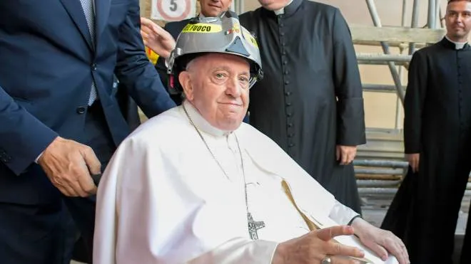 Pope Francis during his Pastoral Visit, for Celestinian Forgiveness (Perdonanza Celestiniana), in L'Aquila with the opening of the Holy Door in the churchyard of the Basilica of Santa Maria di Collemaggio, Italy, 28 August 2022. To safely visit the Cathedral (Duomo), supported by scaffolding and not yet accessible after the earthquake, Pope Francis wore a safety helmet that was given to him by the fire brigade. The Pontiff is carrying out all the movements in a wheelchair. The Celestinian Forgiveness is a religious and historical annual event held in L'Aquila, Italy, at the end of August. It is a catholic jubilee celebration, established in 1294 by Pope Celestine V with his bull Inter sanctorum solemnia (also known as Bull of Pardon or Bull of Forgiveness). Since 2011 the celebration is a "Heritage of Italy for tradition" and in 2019 it was inscribed in the UNESCO Representative List of the Intangible Cultural Heritage of Humanity. On 06 April 2009 an earthquake of 6.3 magnitude struck central Italy with its epicentre near L'Aquila. The earthquake caused damage to between 3.000 and 10.000 buildings in the city. Several buildings also collapsed. 308 people were killed by the earthquake, and approximately 1.500 people were injured. Around 65.000 people were made homeless. 
ANSA/VATICAN MEDIA
+++ ANSA PROVIDES ACCESS TO THIS HANDOUT PHOTO TO BE USED SOLELY TO ILLUSTRATE NEWS REPORTING OR COMMENTARY ON THE FACTS OR EVENTS DEPICTED IN THIS IMAGE; NO ARCHIVING; NO LICENSING +++