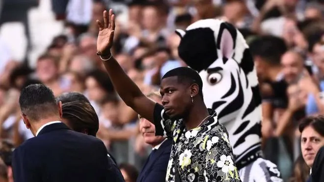 Juventus' French midfielder Paul Pogba, who is currently injured, waves from a tribune prior to the Italian Serie A football match between Juventus and AS Roma on August 27, 2022 at the JUventus stadium in Turin. (Photo by Marco BERTORELLO / AFP)