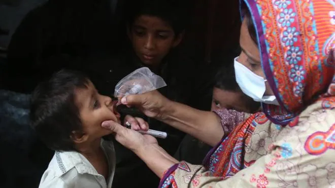 epa10122205 A health worker administers polio drops to a child during a polio vaccination campaign in Karachi, Pakistan, 15 August 2022. According to UNICEF, repeated immunizations have protected millions of children from polio, allowing almost all countries in the world to become polio-free, aside from the two endemic countries of Pakistan and Afghanistan.  EPA/REHAN KHAN
