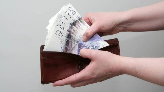 British banknotes being put in /taken out of a wallet