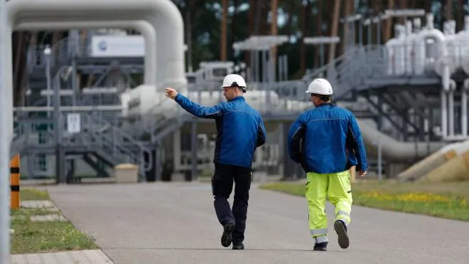 Workers walk past facilities to receive and distribute natural gas on the grounds of gas transport and pipeline network operator Gascade in Lubmin, northeastern Germany, close to the border with Poland, on August 30, 2022. - Lubmin's industrial infrastructure includes a receiving and distribution station for the Nord Stream 1 pipeline and is also the place where the finally canned Nord Stream 2 pipeline for more gas from Russia comes to shore. The construction of a terminal to receive LNG at the site is planned. Government measures to assure supplies of gas over the winter have prepared Germany to deal with further curbs in Russian deliveries, Chancellor Olaf Scholz said on August 30, 2022, a day before Moscow is due to cut off gas supplies for three days. (Photo by Odd ANDERSEN / AFP)