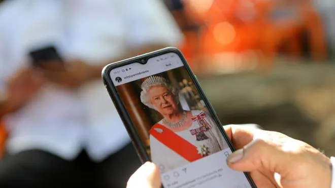 epa10172391 A person reads about the passing of Britain�s Queen Elizabeth II on his mobile phone in Banda Aceh, Indonesia, 09 September 2022. Britain's Queen Elizabeth II died at her Scottish estate on 08 September 2022. The 96-year-old Queen was the longest-reigning monarch in British history.  EPA/HOTLI SIMANJUNTAK