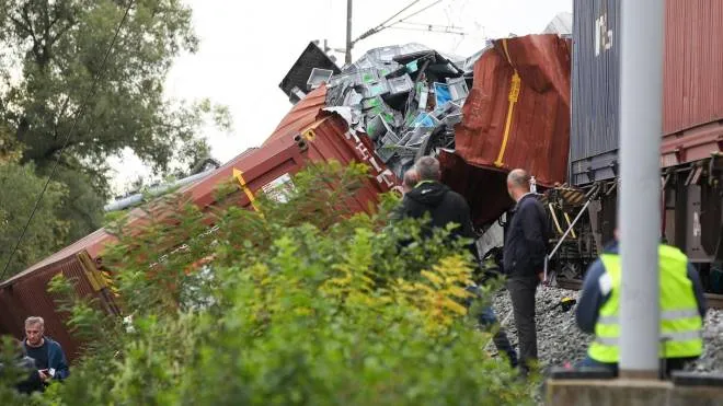 Officials stand next to train wreckage after a passenger train and a stationary freight train collided, near Novska, on September 10, 2022. - At least three people were killed and several were injured late September 9, 2022 in a collision of a passenger train and freight train in central Croatia. (Photo by DAMIR SENCAR / AFP)