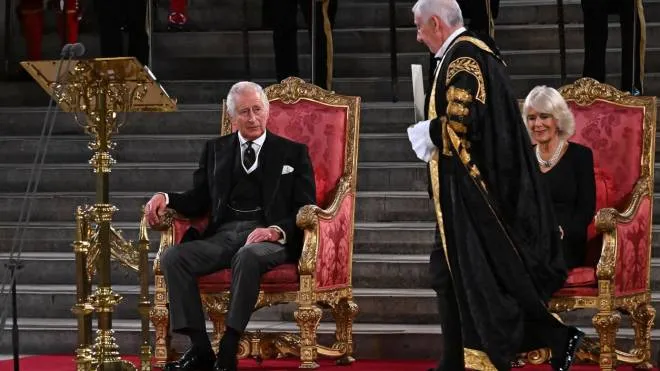 Britain's Speaker of The Commons Lindsay Hoyle (2R) walks past Britain's Camilla, Queen Consort (R) to hand a document to Britain's King Charles III during the presentation of Addresses by both Houses of Parliament in Westminster Hall, inside the Palace of Westminster, central London on September 12, 2022, following the death of Queen Elizabeth II on September 8. (Photo by Ben Stansall / various sources / AFP)