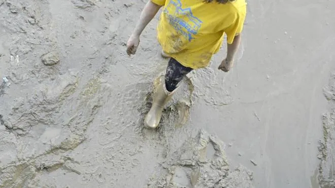 Un uomo cammina nel fango a Pianello di Ostra, la più colpita dall’alluvione dell’altro giorno