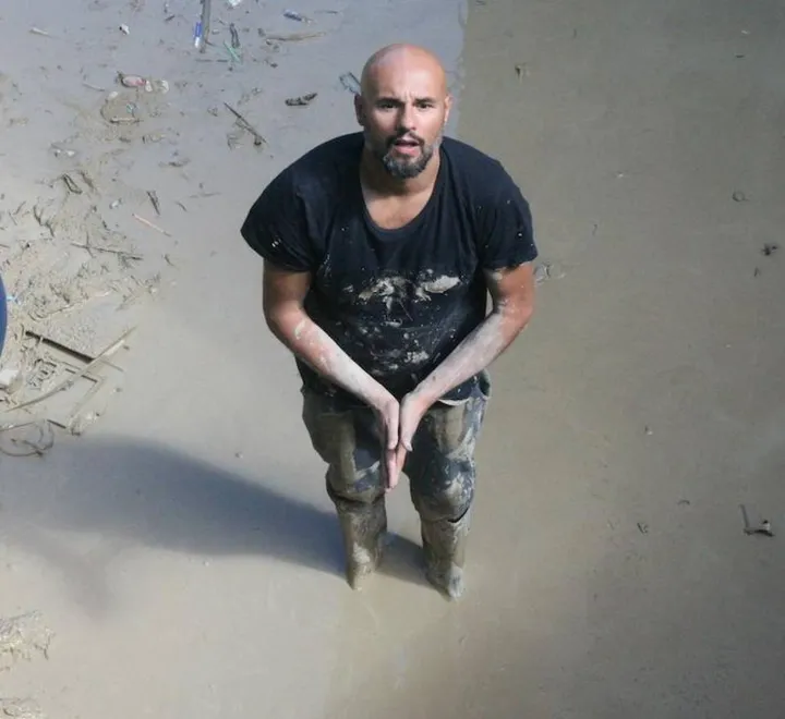Un residente di Barbara, nell’Anconetano, immerso nel fango provocato dall’alluvione